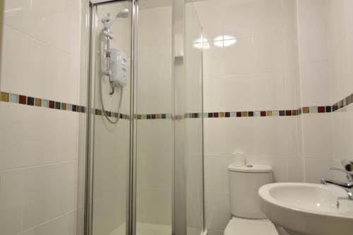 a bathroom with a shower and a toilet and a sink at King's Cross Quiet Apartment in London