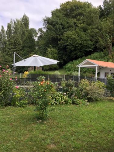 - un jardin avec un parasol blanc dans la cour dans l'établissement gîte au Pays Basque entre mer et montagne, à Villefranque