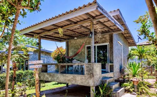 a patio with a wooden pergola on a house at New Moon in Thongsala