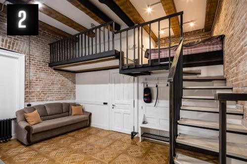 a living room with a couch and a spiral staircase at The Heart of Lviv Apartments - Lviv in Lviv