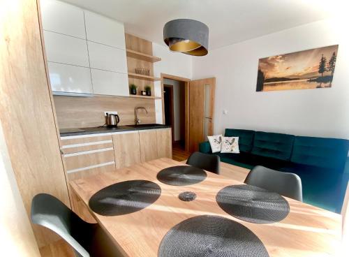 a dining room table with chairs and a kitchen at Apartmán Na Břehu Lipna in Černá v Pošumaví