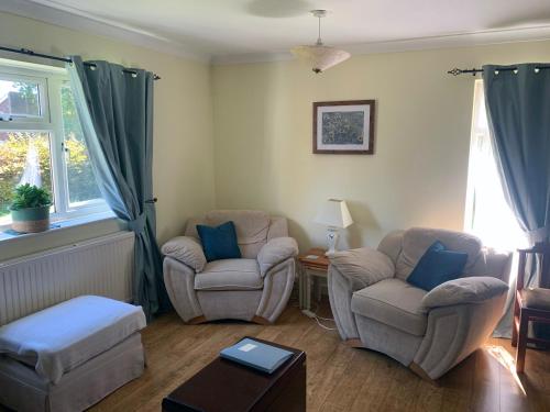 1 Bedroom Apartment Central Basingstoke في باسينغستوك: غرفة معيشة مع كرسيين وطاولة