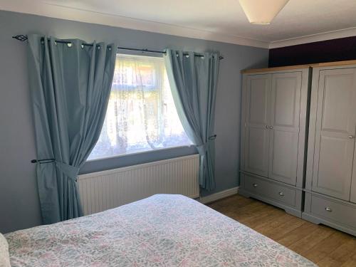 a bedroom with a bed and a window with blue curtains at 1 Bedroom Apartment Central Basingstoke in Basingstoke
