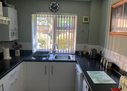 a kitchen with a sink and a clock on the wall at 1 Bedroom Apartment Central Basingstoke in Basingstoke
