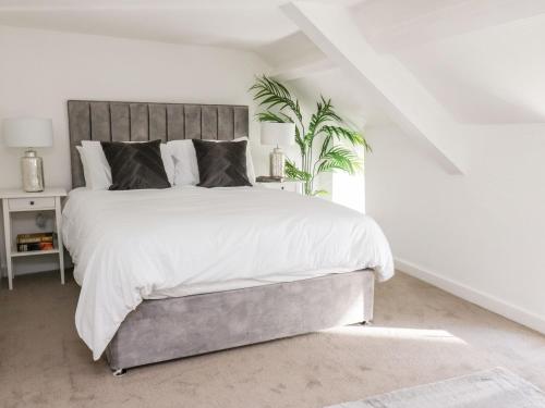 a bedroom with a large bed with white sheets at Lane Cottage in Cardigan