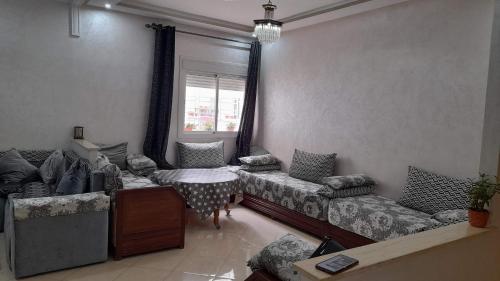 a living room with couches and a table and a window at Appartement au centre de la ville de Meknès in Meknès