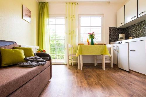 a living room with a couch and a kitchen with a table at Ferienpark am Darß - Apartmenthaus 1 in Fuhlendorf