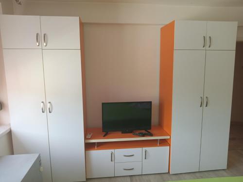 Zimmer mit weißen Schränken und einem Schreibtisch mit TV in der Unterkunft Apartman Vojka in Višegrad