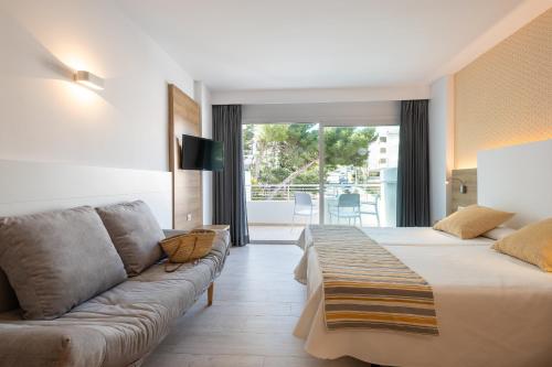 a hotel room with a couch and a living room at Casablanca Apartments, Santa Ponsa in Santa Ponsa
