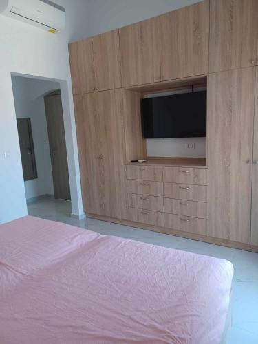 a bedroom with a entertainment center with a flat screen tv at Gianna's Studio in Pastida
