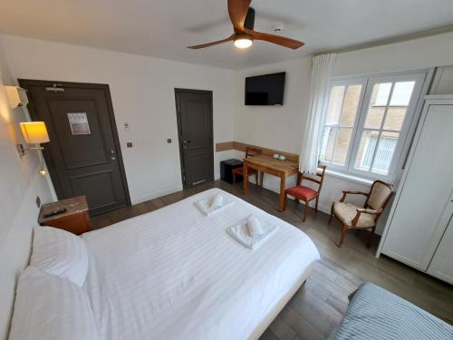 a bedroom with a large white bed with a ceiling fan at B&B Pickery in Bruges