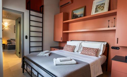 a bedroom with a bed with orange walls and shelves at Villa Hermes in Anafiotika Athens ! in Athens
