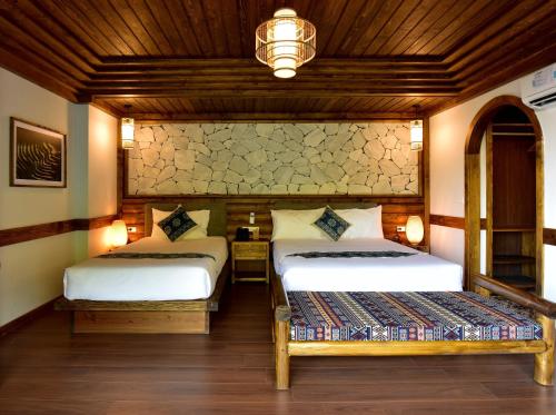 a bedroom with two beds and a chandelier at Maison de Lao Chai in Sa Pa