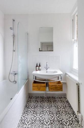 a white bathroom with a sink and a shower at Flat cannot be booked in London