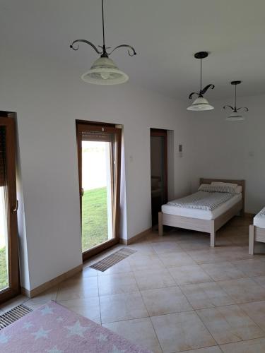 a bedroom with a bed and a door to a yard at Ogrodowe Noclegi 2 in Pelczyce