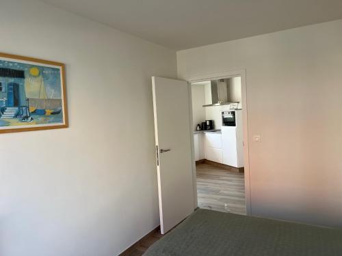 德哈恩的住宿－De Haan App 1，白色的房间,墙上挂有绘画