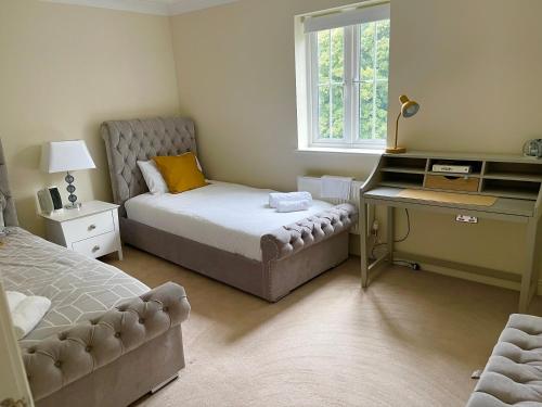 a bedroom with a bed and a desk and a bed sidx sidx sidx at Large Executive 4-Bed Detached House in Miskin, Cardiff-sleeps up to 10 in Hensol