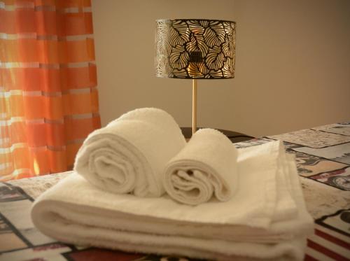 a pile of towels on a table next to a lamp at CivicoNove in Piombino