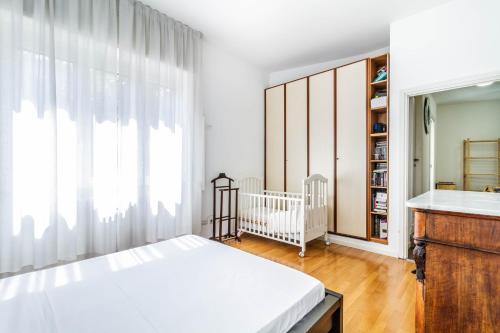 um quarto com um berço e uma grande janela em DomusMi Gozzano-4 em Milão