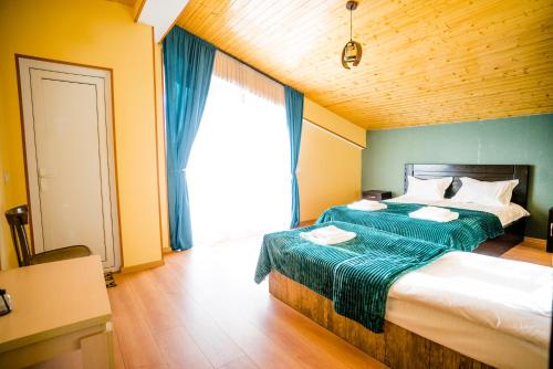 a bedroom with two beds and a large window at Sunny hill in Gudauri