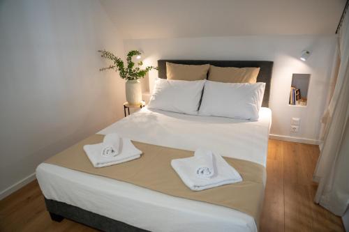 a bedroom with a large bed with towels on it at Loft Studios in Artemida