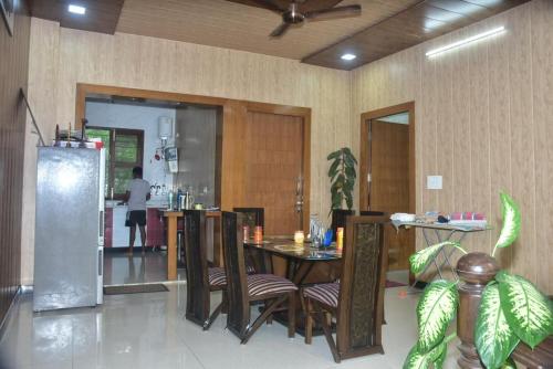 a dining room with a table and chairs and a kitchen at Shreshth Home Stay - Best Family Accommodation - 3km from Har Ki Pauri, Haridwar, Uttarakhand in Haridwār