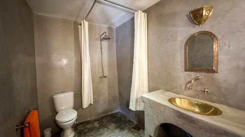 uma casa de banho com um lavatório dourado e um WC em Alliance Berbère - Vallée d'Aït Bouguemez em Timit