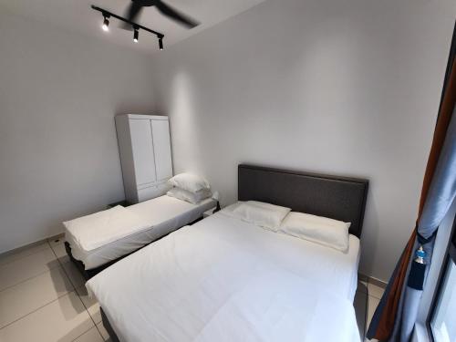 two beds in a small room with white walls at Horizon Premium Suite - Ipoh in Ipoh