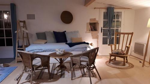 uma sala de estar com uma mesa e um sofá em Loft atypique pour 2 personnes em Nieulle-sur-Seudre