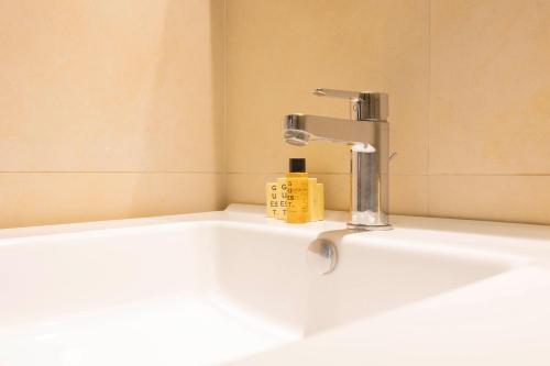La salle de bains est pourvue d'un lavabo et d'un robinet. dans l'établissement Capponi Deluxe Apartment, à Florence
