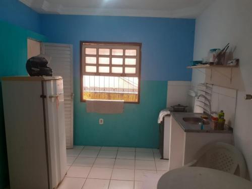 uma cozinha azul com um lavatório e uma janela em apartamento itapua em Salvador