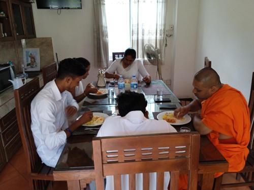 a group of people sitting around a table eating food at Vino Villa Tourists & Local Accommodations - 24 Hrs in Kandy