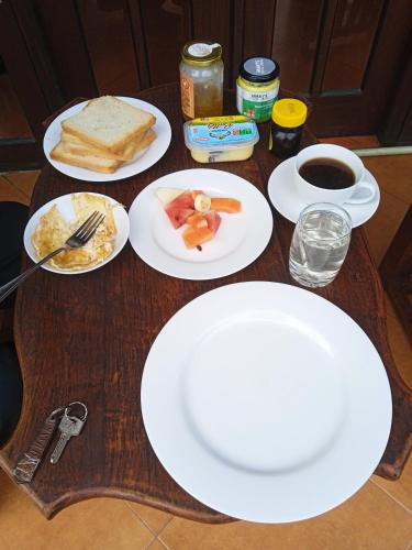 a table with plates of food and a cup of coffee at Vino Villa Tourists & Local Accommodations - 24 Hrs in Kandy