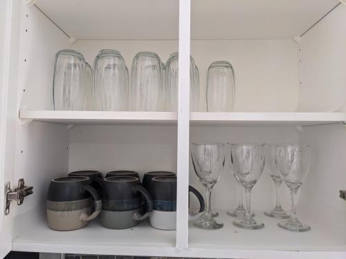 a cupboard filled with glasses and wine glasses at Adorable 4 bed,3 bath house in Kingston