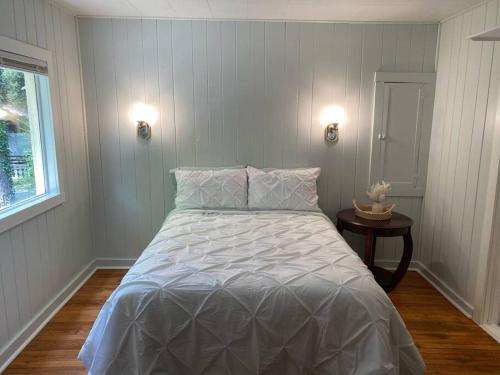a white bed in a room with a window at The Garden Cottage in Hendersonville