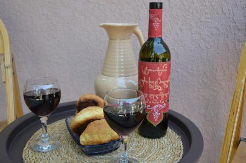 a table with two glasses of wine and a bottle of wine at Terrace Center in Kutaisi