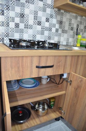 a kitchen cabinet with a stove and dishes in it at Terrace Center in Kutaisi
