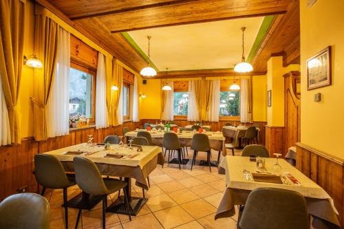 restauracja ze stołami i krzesłami w pokoju w obiekcie Hotel Bijou w mieście Valtournenche