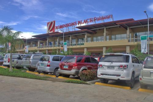 a line of cars parked in front of a store at Deep Forest Garden Hotel in Puerto Princesa City