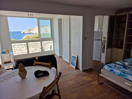 een slaapkamer met een tafel en een bed en uitzicht op de oceaan bij Une parenthèse au Frioul in Marseille