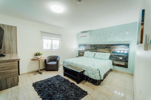 a bedroom with a bed and a table and a chair at Hotel RH Boutique Aruba in Oranjestad