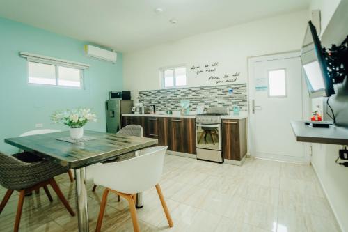 a kitchen with a table and chairs and a stove at Hotel RH Boutique Aruba in Oranjestad