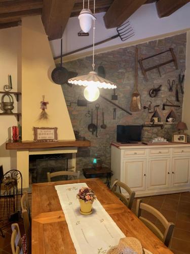 a kitchen with a wooden table and a stone wall at Il Forcone in Panicale