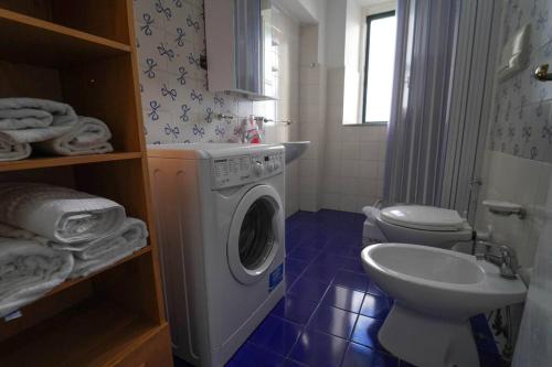 uma casa de banho com uma máquina de lavar roupa e um WC em Casa panoramica con terrazzo em Cetara