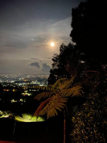 a view of a city at night with the moon at LAS NUBES - Donde la energía fluye, el alma se cura in Rionegro