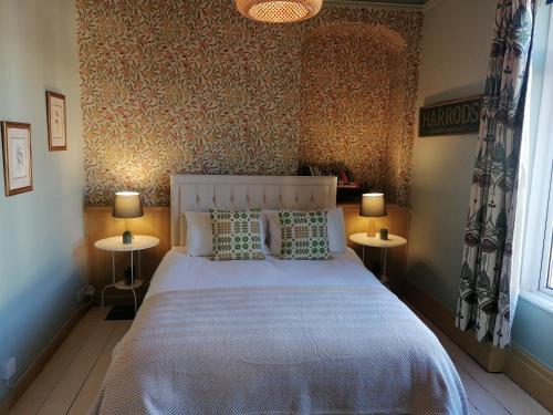 een slaapkamer met een wit bed en 2 tafels bij No. 30 in Aberdare