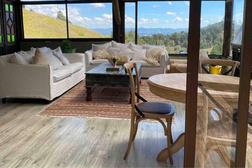 a living room with a table and a couch and a table and chair at LAS NUBES - Donde la energía fluye, el alma se cura in Rionegro