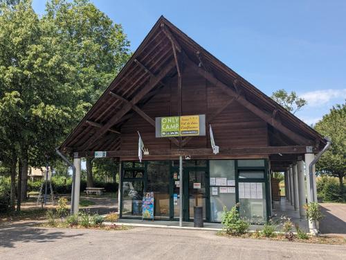 un bâtiment avec un toit en bois dans un parc dans l'établissement Camping Onlycamp La Confluence, à Savonnières