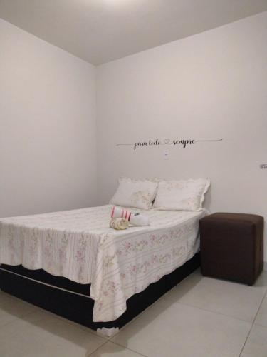 a bedroom with a bed with a sign on the wall at kitnet RAGNAROK in Barão de Cocais