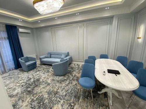 a conference room with a table and blue chairs at Happy home in Tashkent